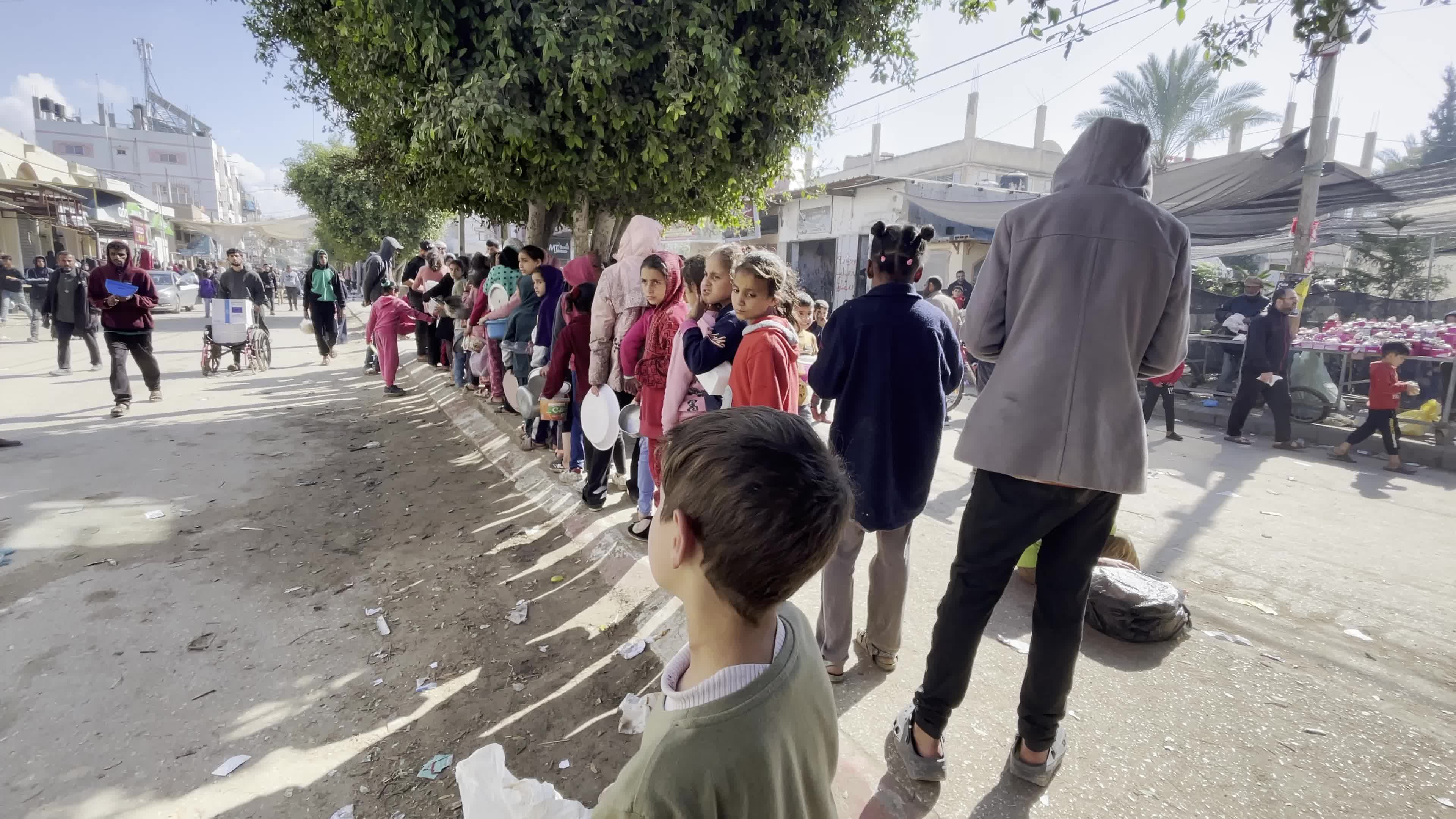 Displaced Palestinians Receive Food at Refugee Camp in Deir al-Balah Amid Israel-Hamas Conflict