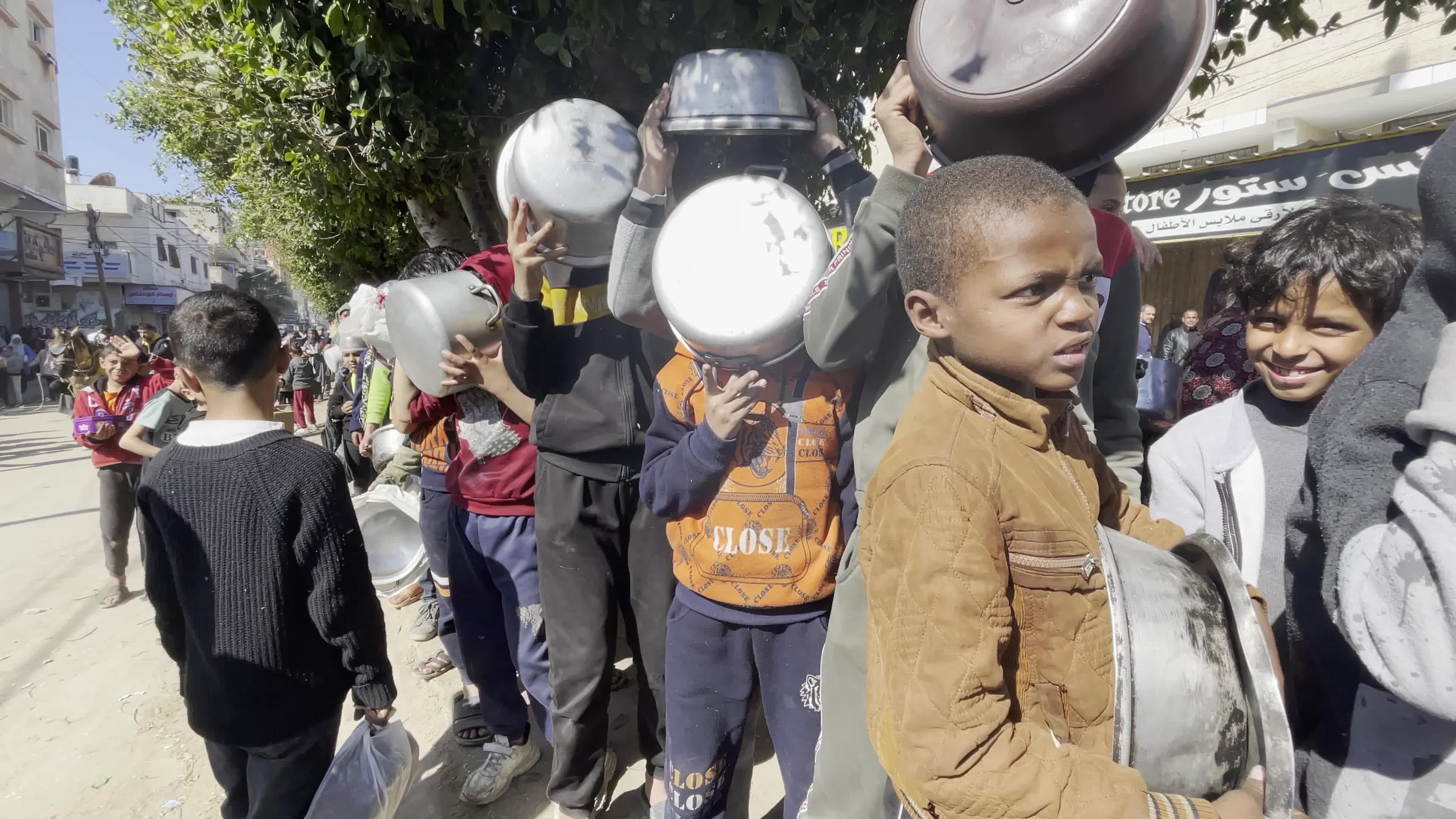 Displaced Palestinians Receive Food at Refugee Camp in Deir al-Balah Amid Israel-Hamas Conflict