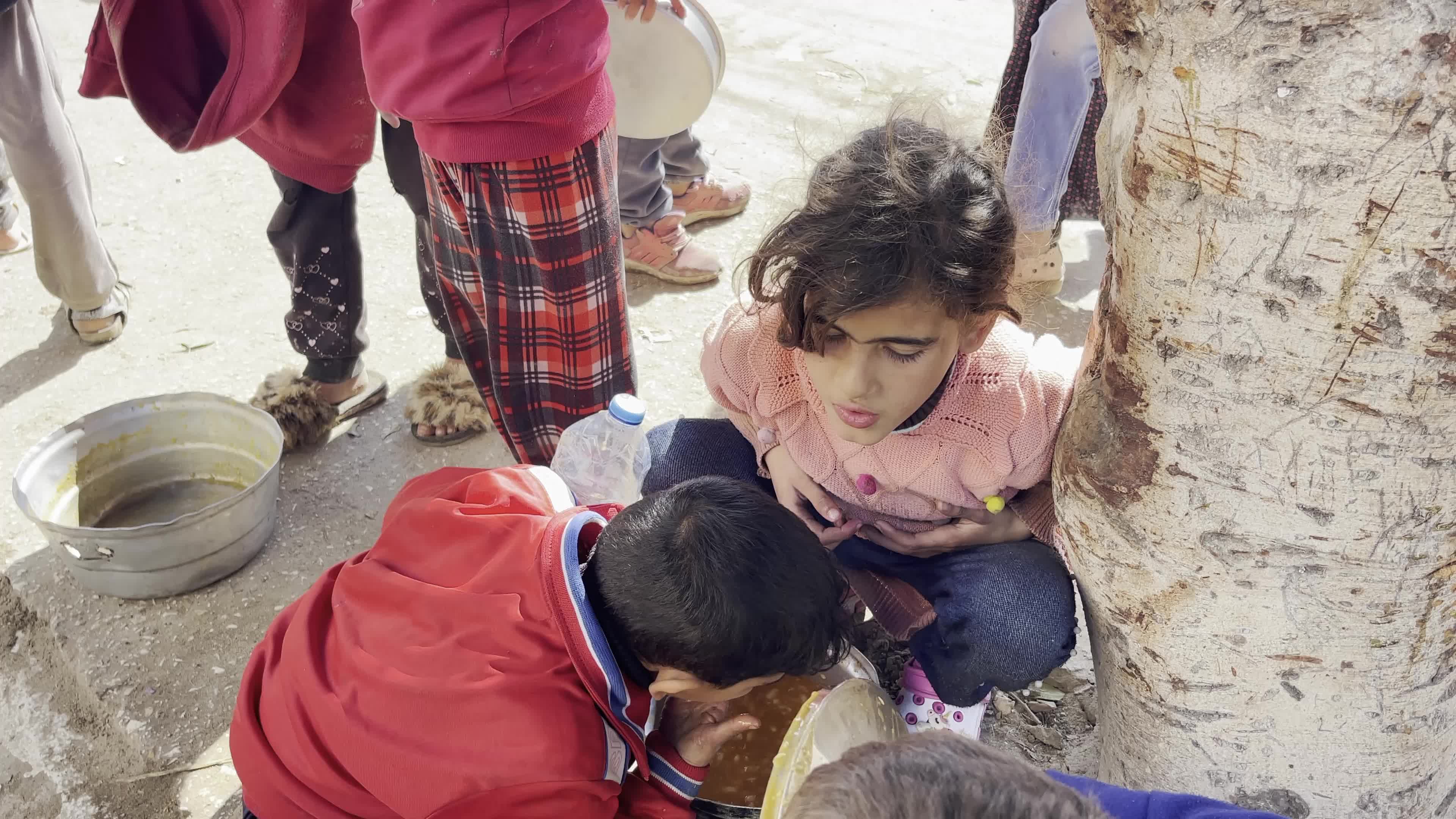 Displaced Palestinians Receive Food at Refugee Camp in Deir al-Balah Amid Israel-Hamas Conflict
