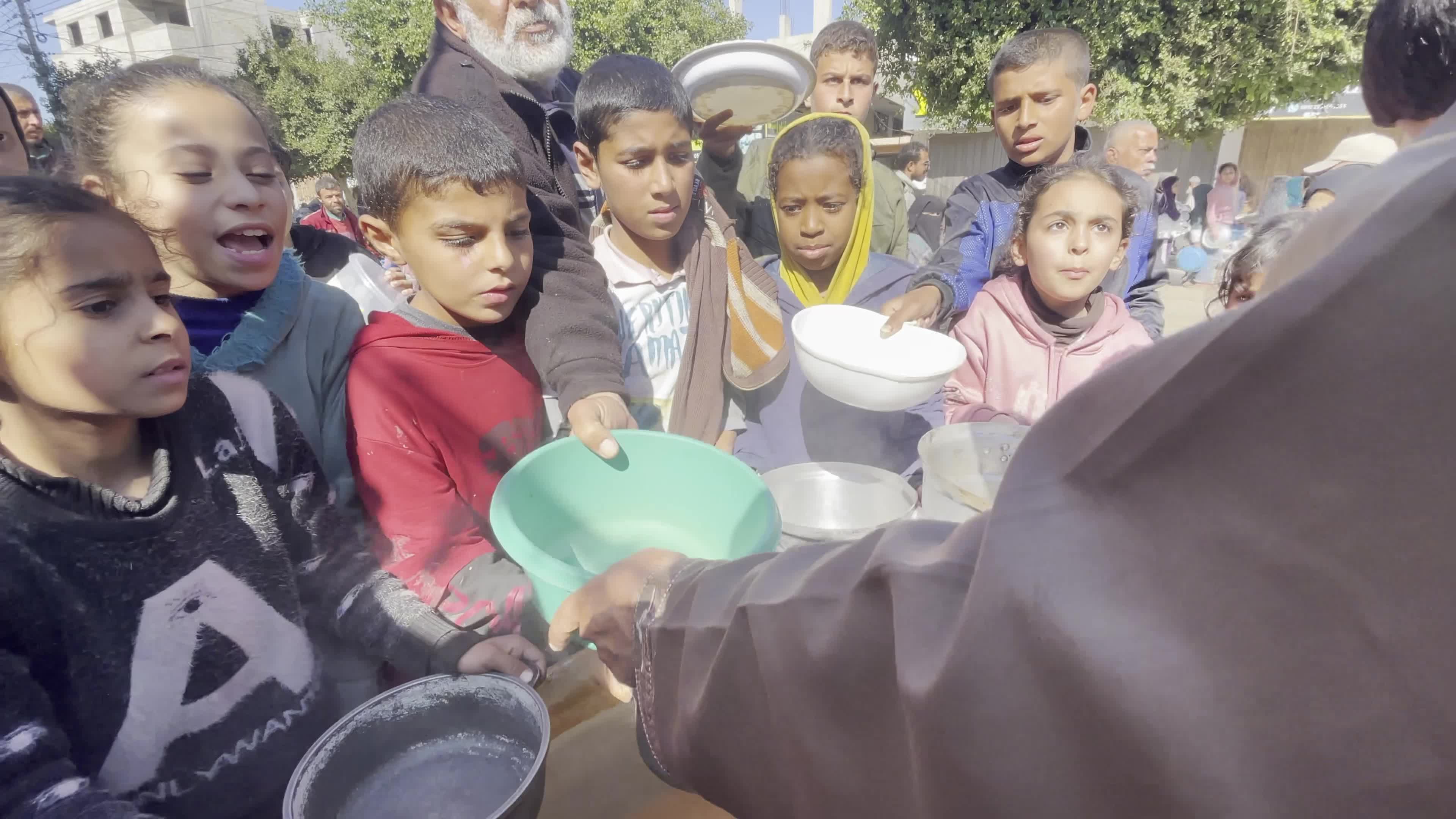 Displaced Palestinians Receive Food at Refugee Camp in Deir al-Balah Amid Israel-Hamas Conflict