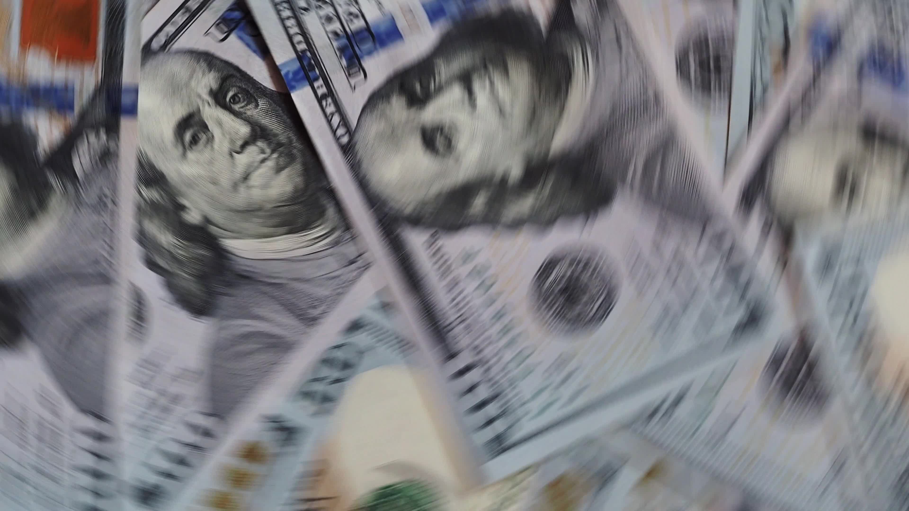 Background of rotating chaotic scattered 100 dollars bills