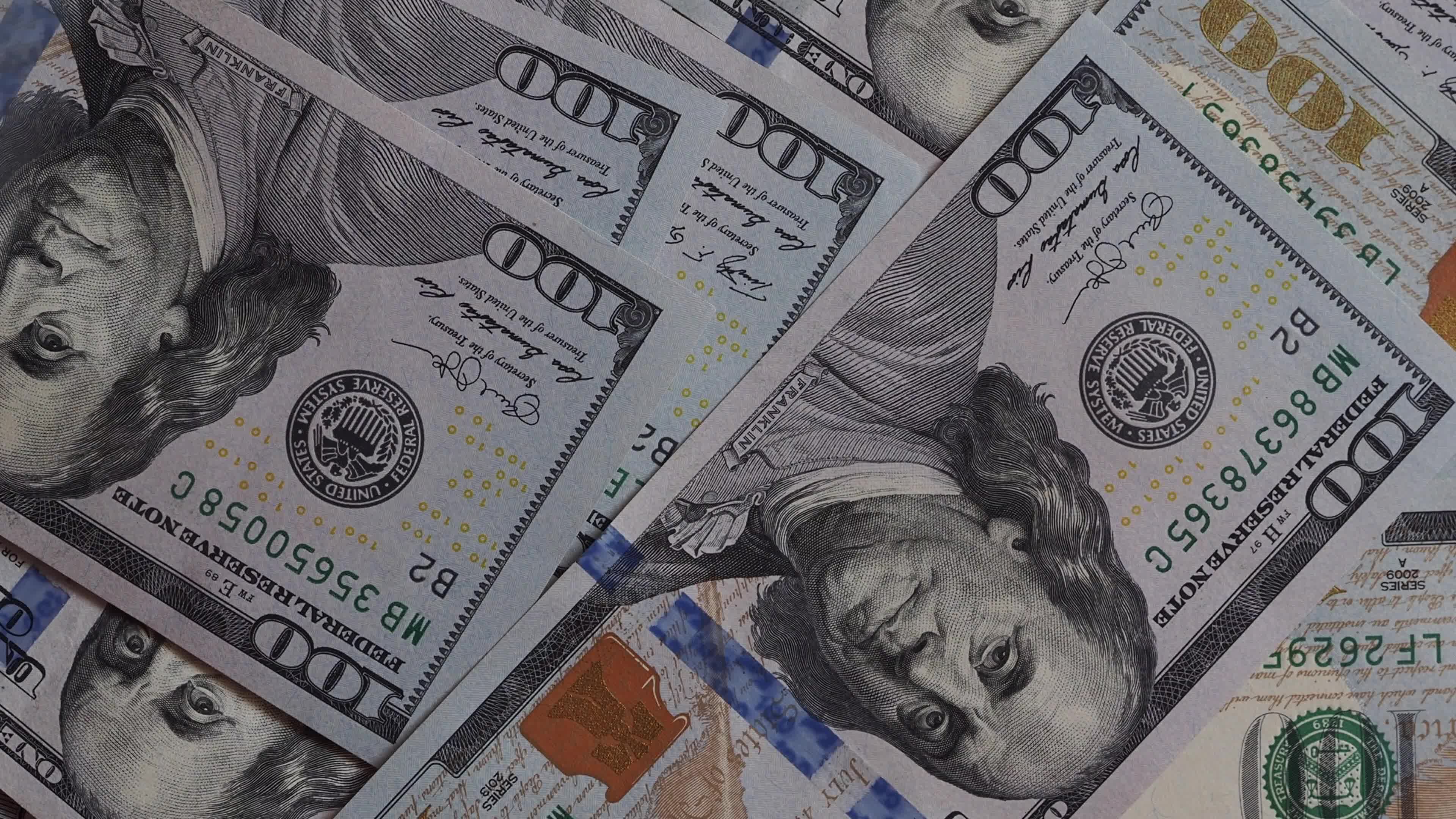 Background of rotating chaotic scattered 100 dollars bills