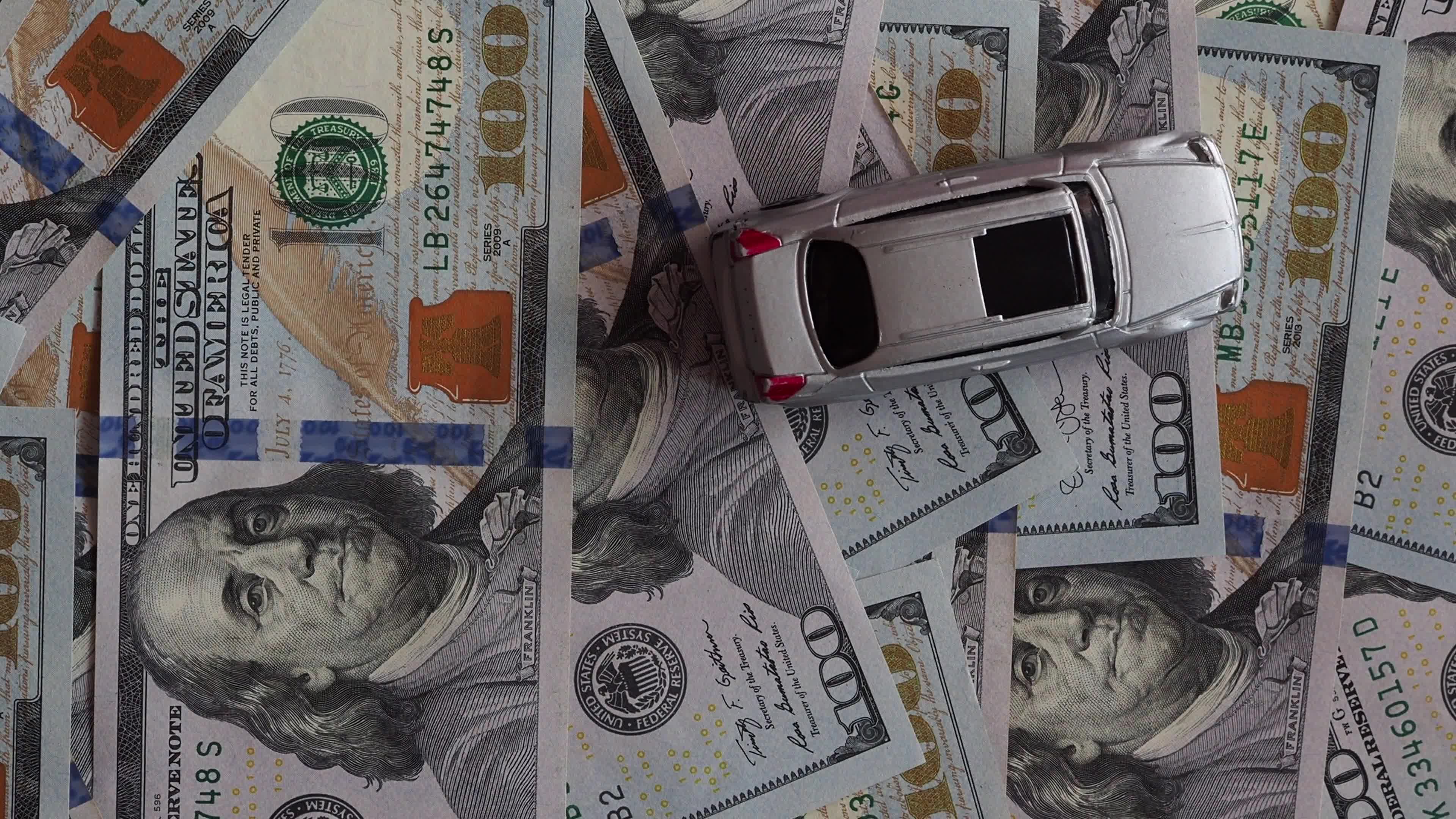 A car model rides, and then stops at 100 dollar bills