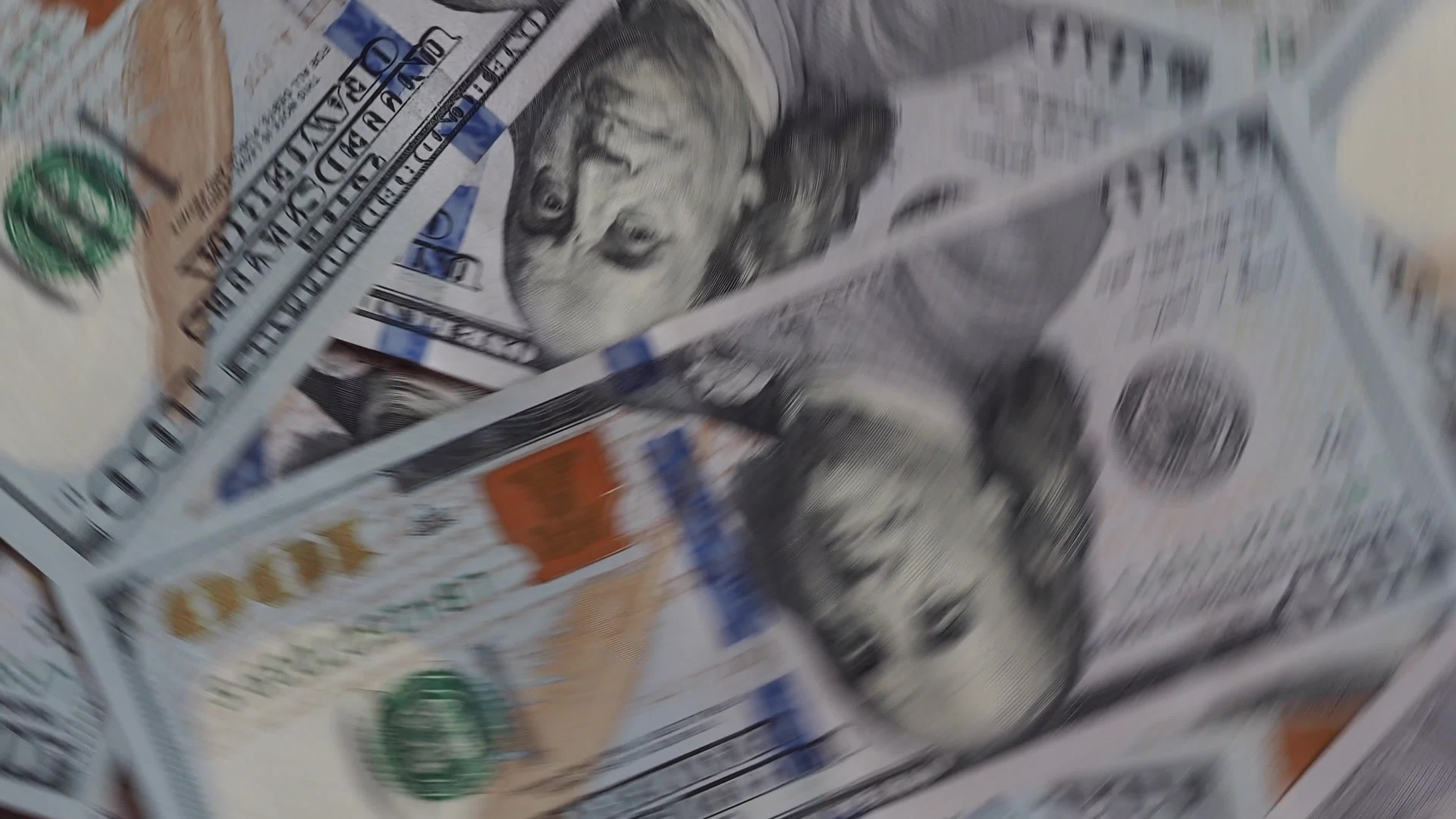 Background of rotating chaotic scattered 100 dollars bills