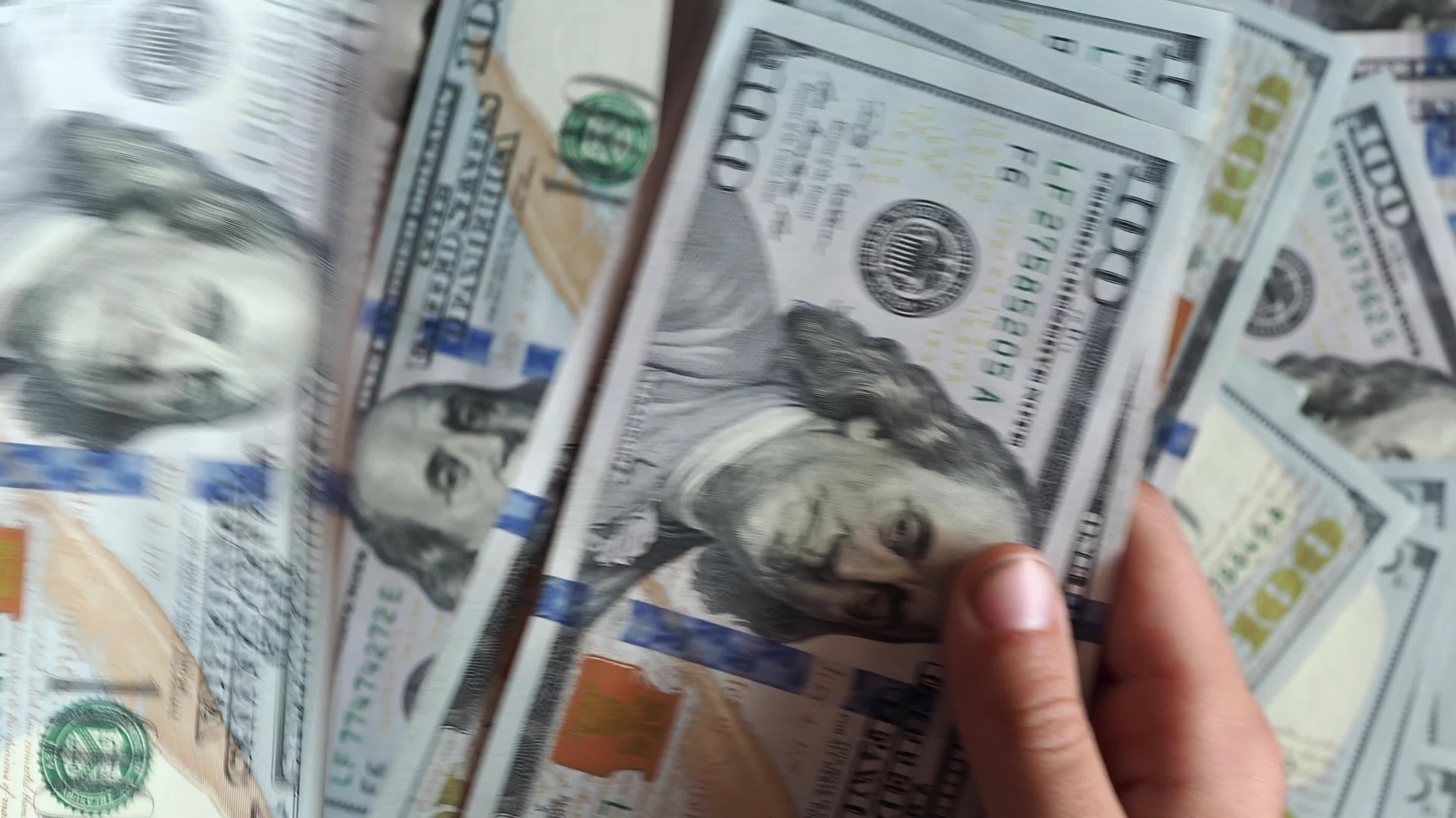 Person counts 100 dollar banknotes in hands