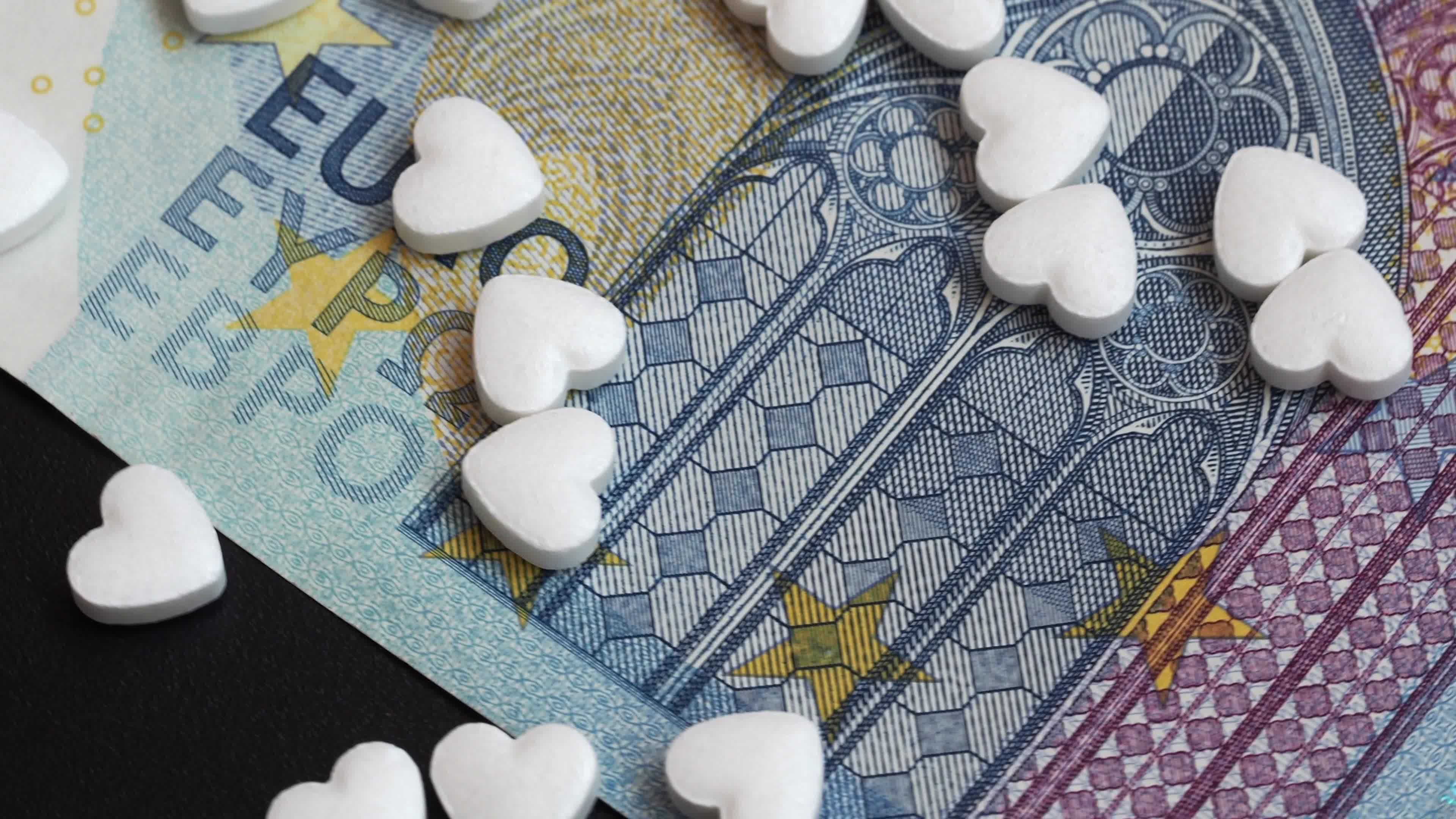 Video illustration many pills in the heart shape is on the 20 euro bills