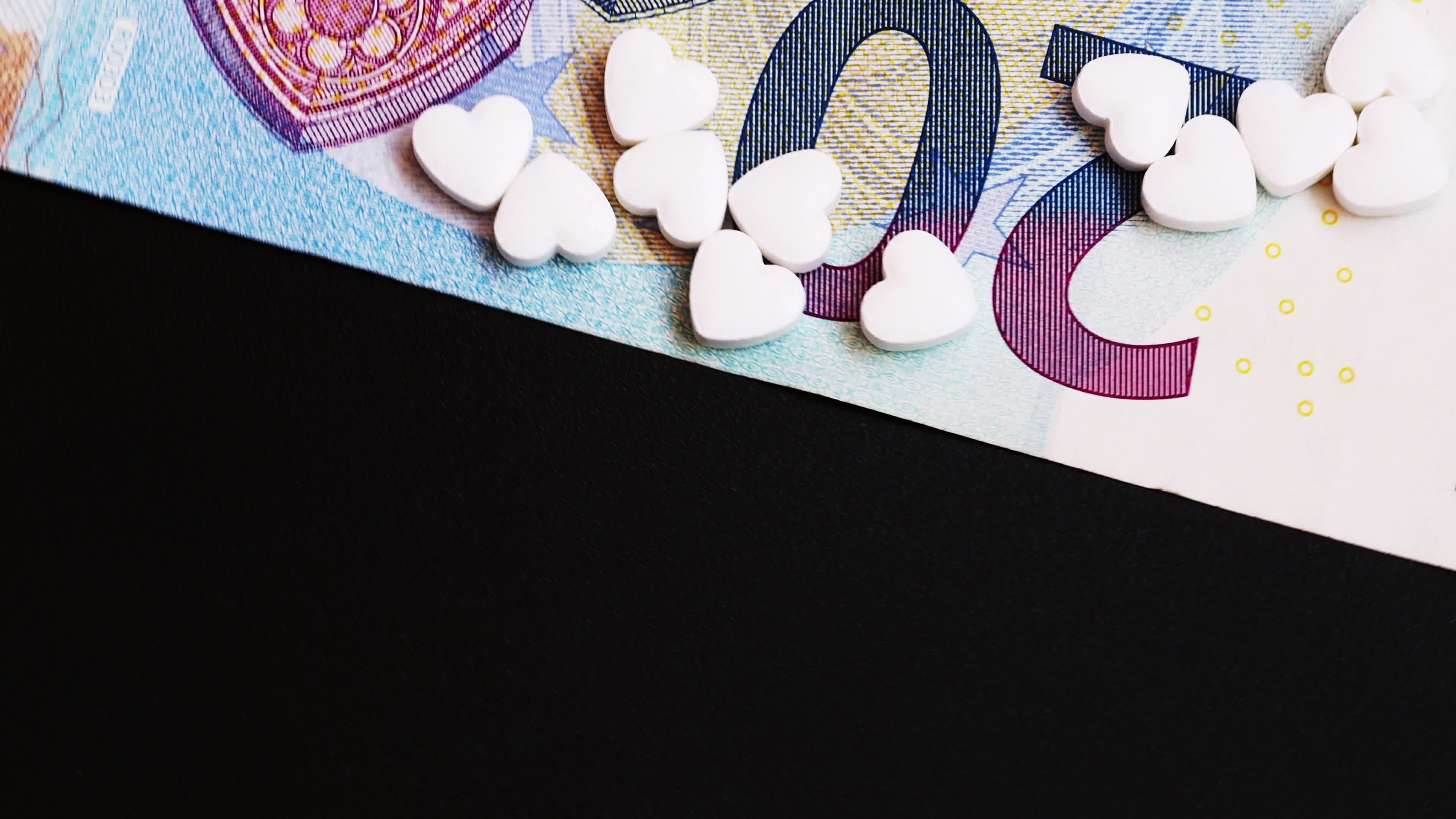 Video illustration many pills in the heart shape is on the 20 euro bills