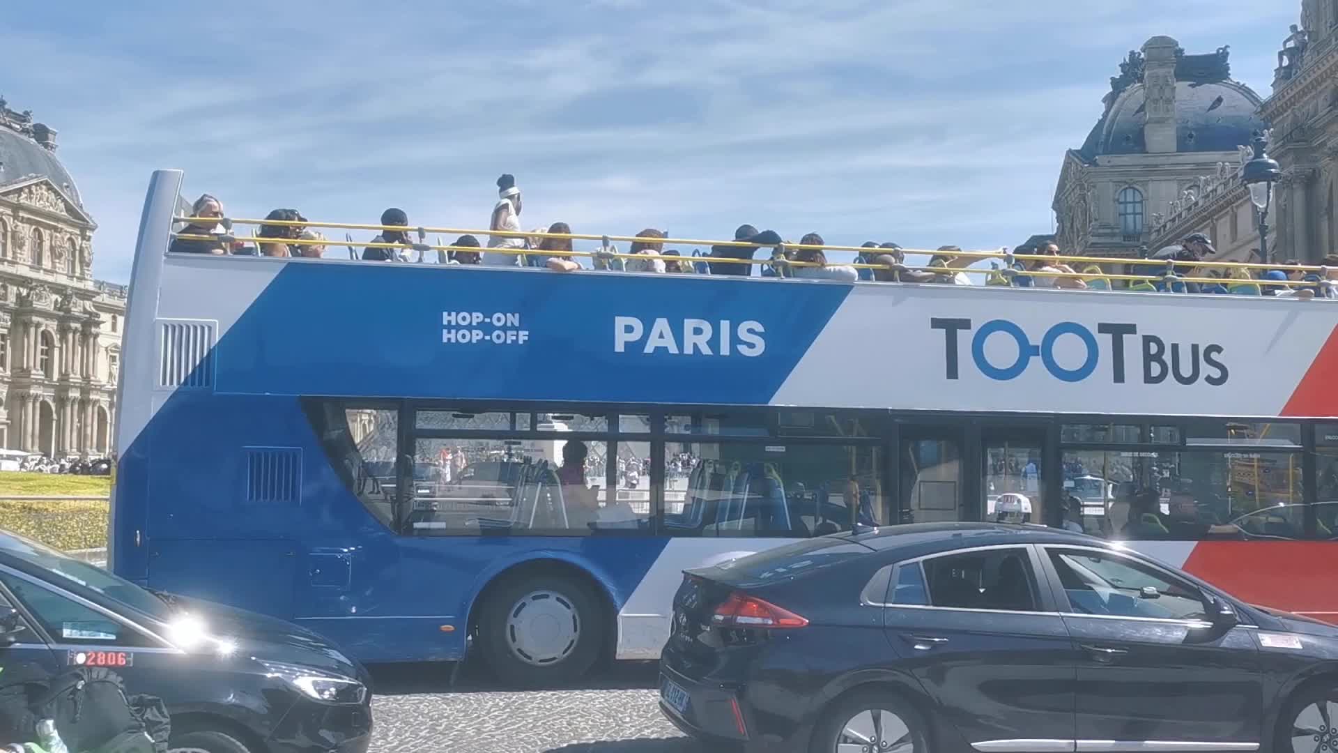 Tourists and Parisians enjoying the sun at the Tuileries Gardens and the Louvre in Paris 