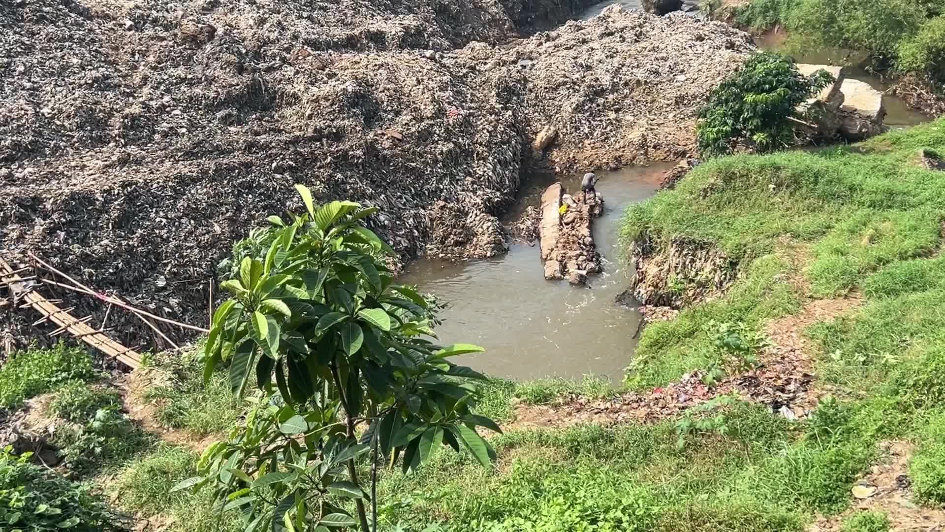 Hill of Garbage waste and poluted river in Indonedia