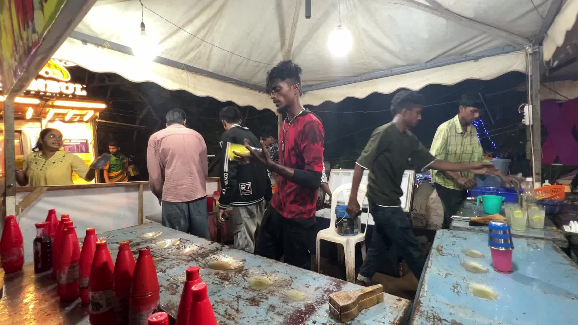 Men perform tricks while they prepare Kulukki Sarbath