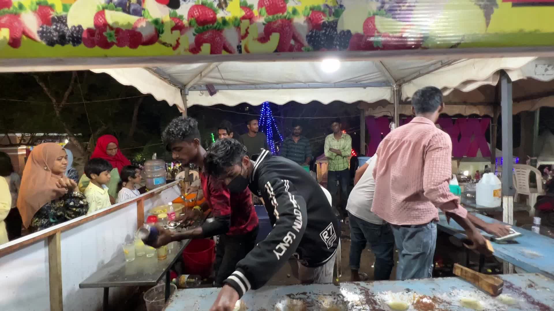 Men perform tricks while they prepare Kulukki Sarbath
