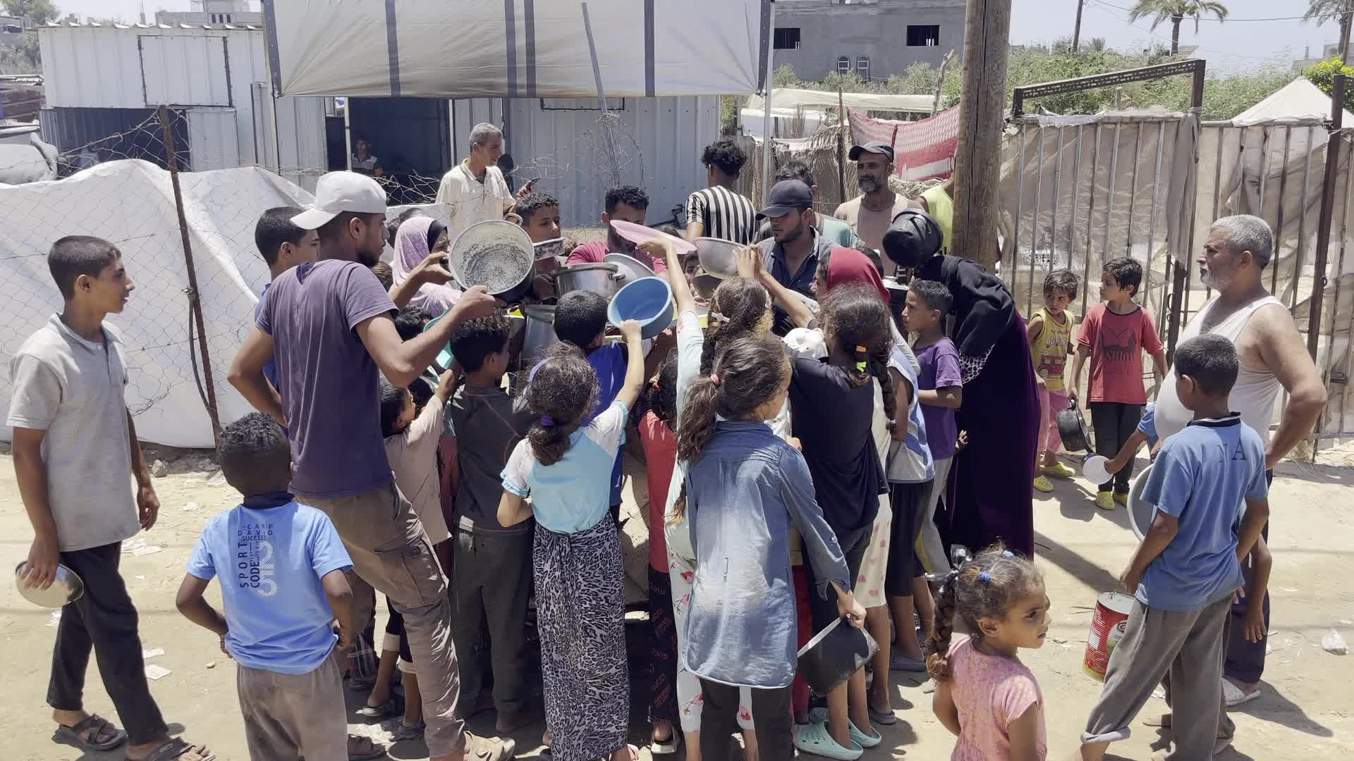 Displaced Palestinian Children Await Food Distribution Amid Ongoing Gaza Conflict