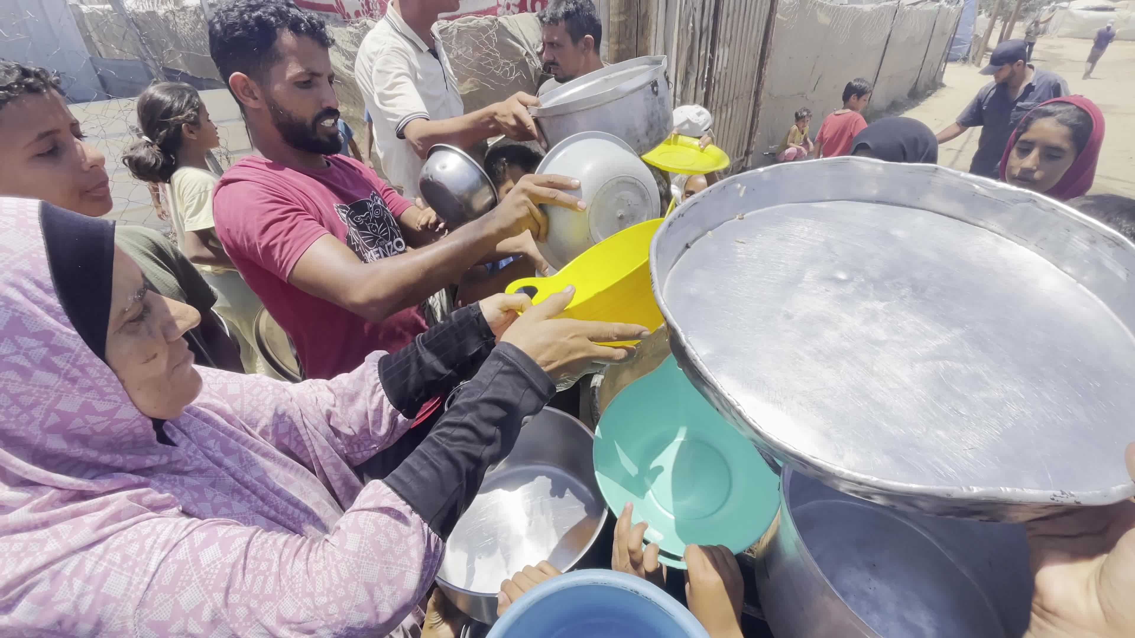 Displaced Palestinian Children Await Food Distribution Amid Ongoing Gaza Conflict