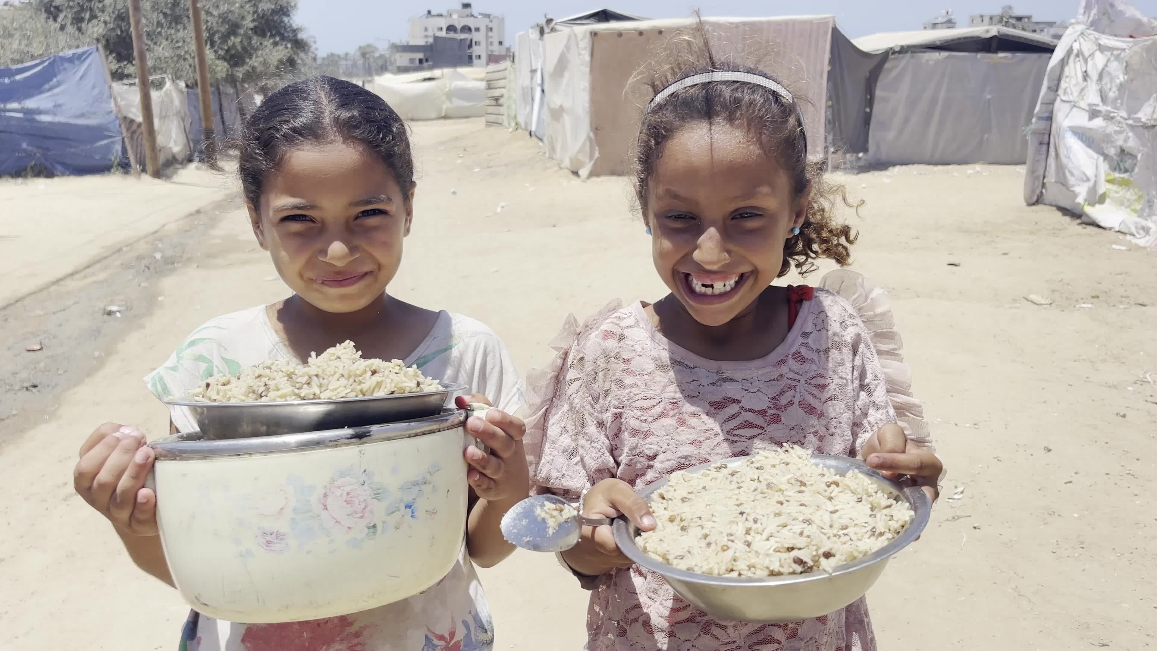 Displaced Palestinian Children Await Food Distribution Amid Ongoing Gaza Conflict