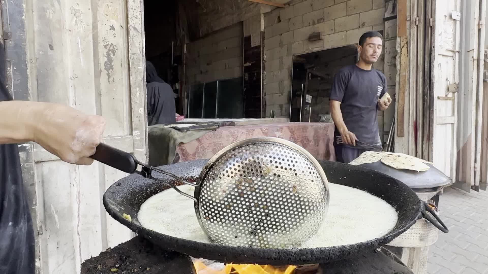 Displaced Palestinian Woman Prepares Flatbread Dough at Stall Kitchen in Central Gaza Strip Amid Ongoing Conflict
