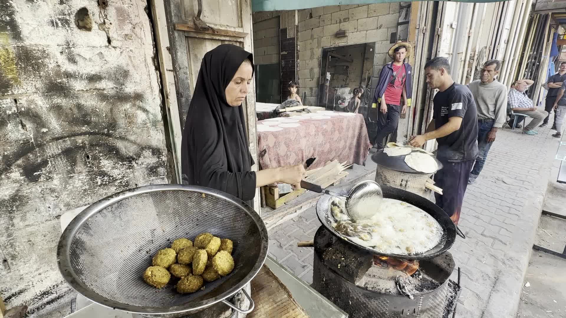 Displaced Palestinian Woman Prepares Flatbread Dough at Stall Kitchen in Central Gaza Strip Amid Ongoing Conflict