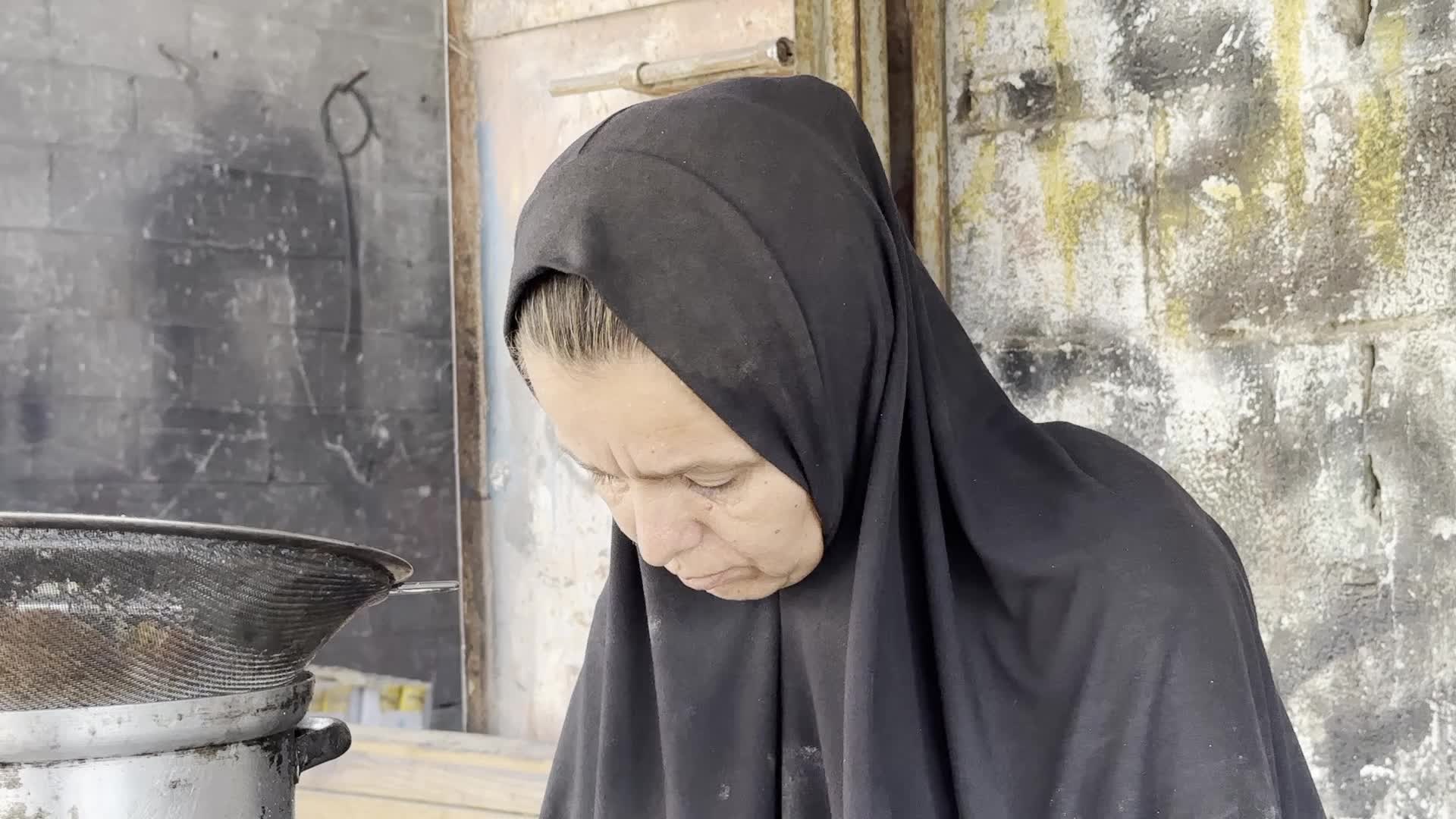 Displaced Palestinian Woman Prepares Flatbread Dough at Stall Kitchen in Central Gaza Strip Amid Ongoing Conflict