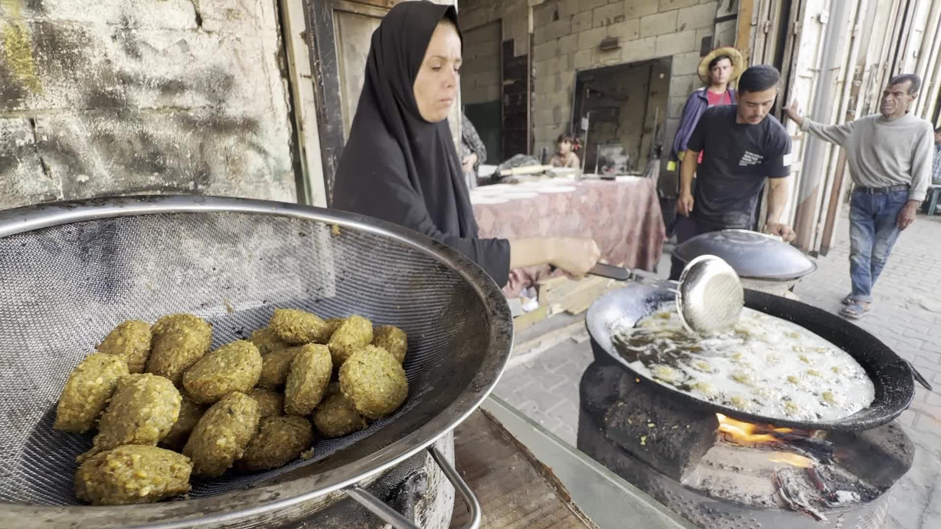 Displaced Palestinian Woman Prepares Flatbread Dough at Stall Kitchen in Central Gaza Strip Amid Ongoing Conflict