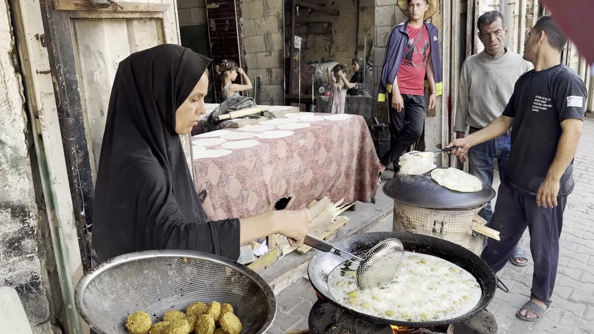 Displaced Palestinian Woman Prepares Flatbread Dough at Stall Kitchen in Central Gaza Strip Amid Ongoing Conflict