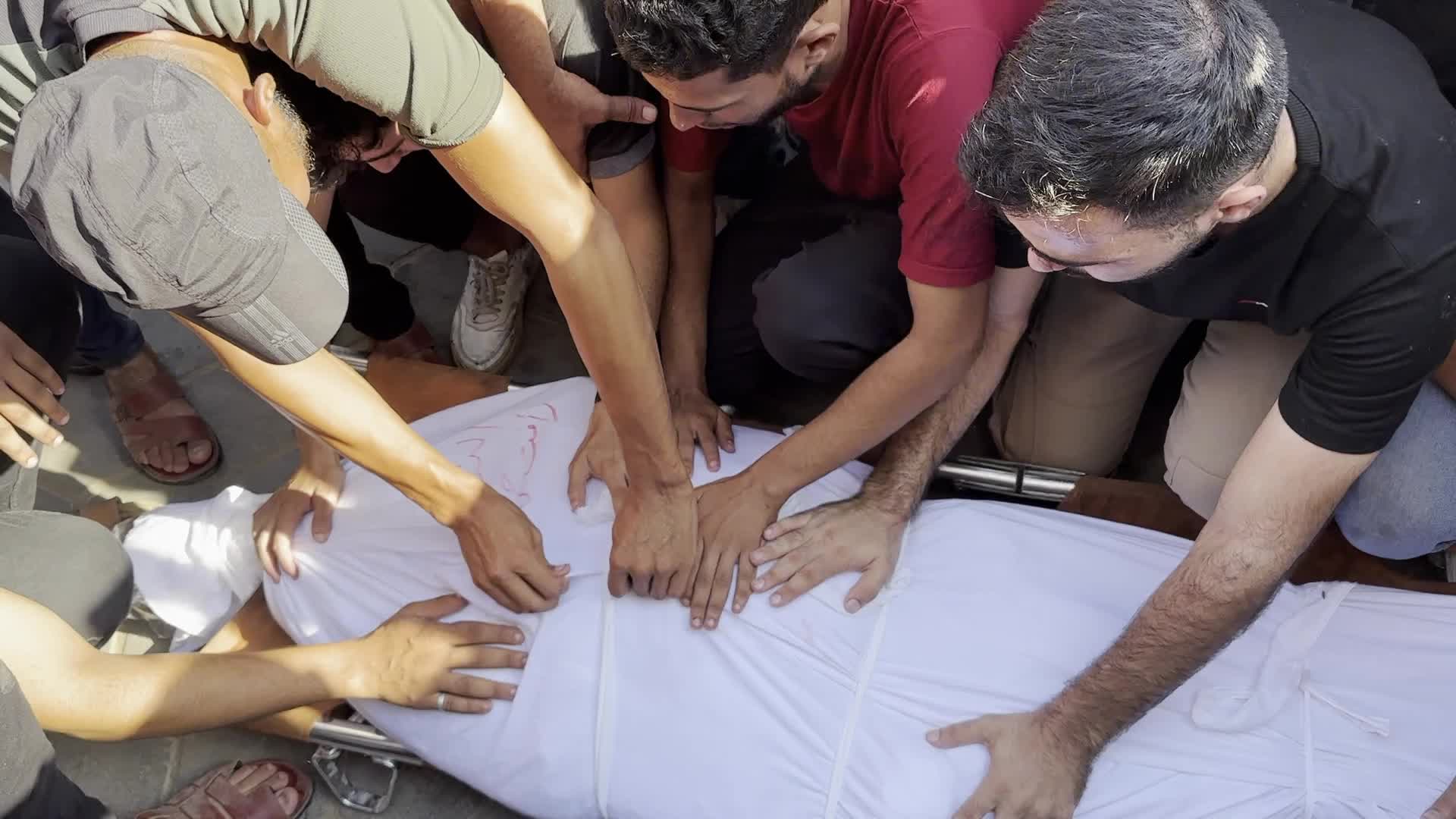 Palestinian Men Pray Over Victims of Israeli Strike at Aqsa Martyrs Hospital in Deir el-Balah