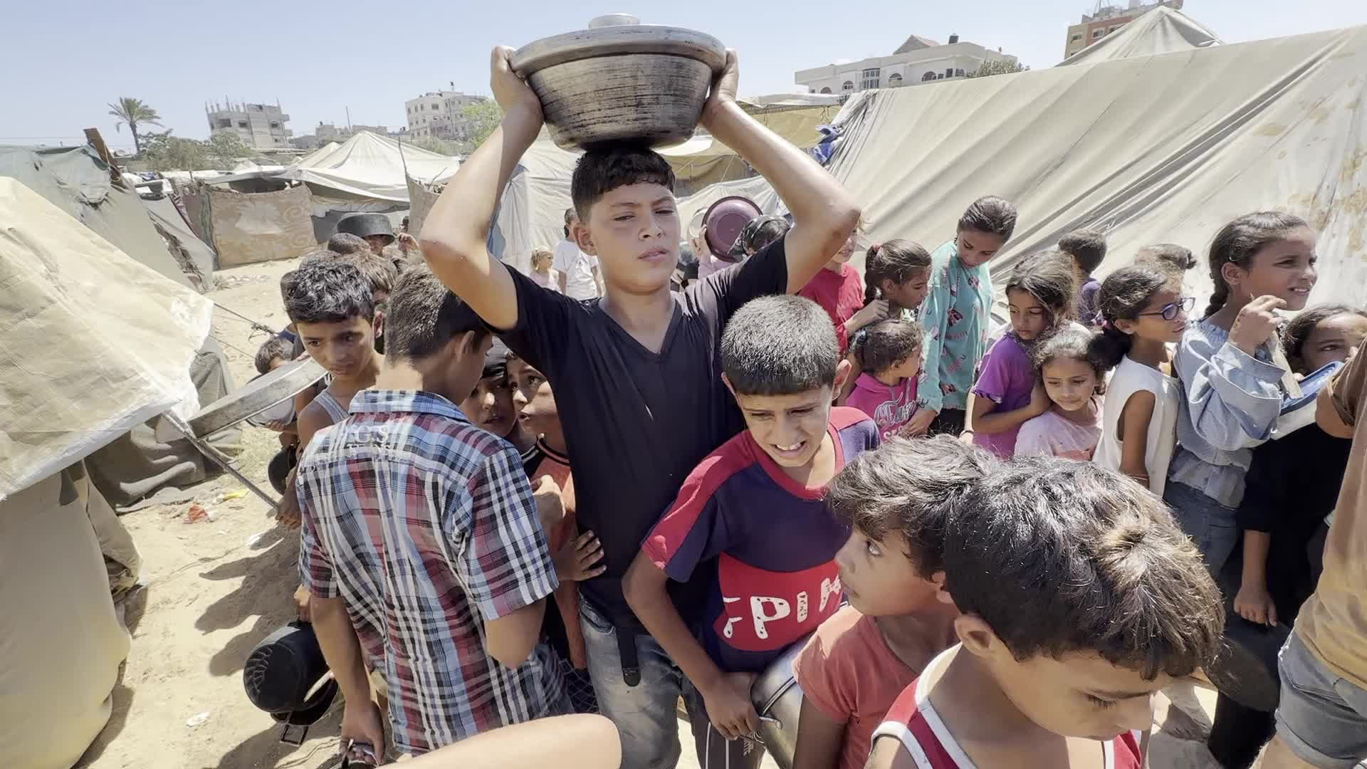 Displaced Palestinians Gather for Charity Food Distribution Amid Ongoing Israel-Hamas Conflict in Al-Zawaida, Central Gaza