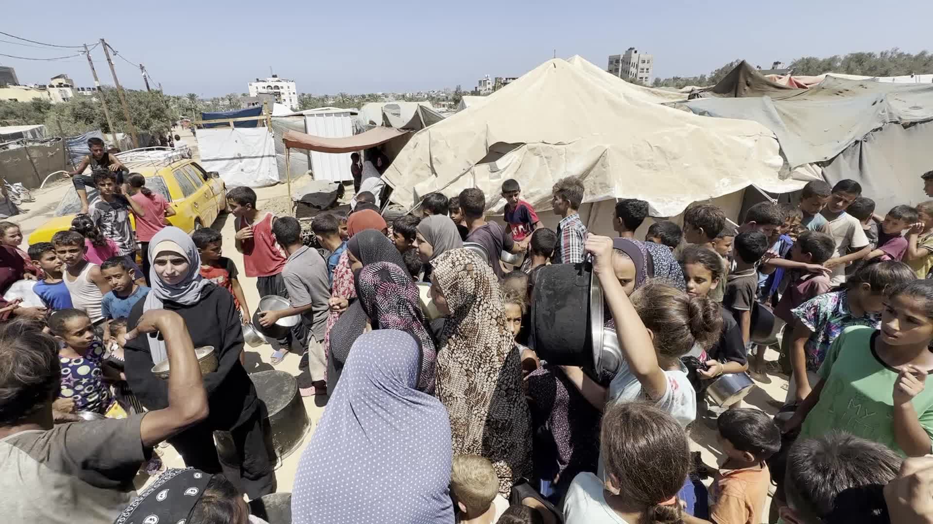 Displaced Palestinians Gather for Charity Food Distribution Amid Ongoing Israel-Hamas Conflict in Al-Zawaida, Central Gaza