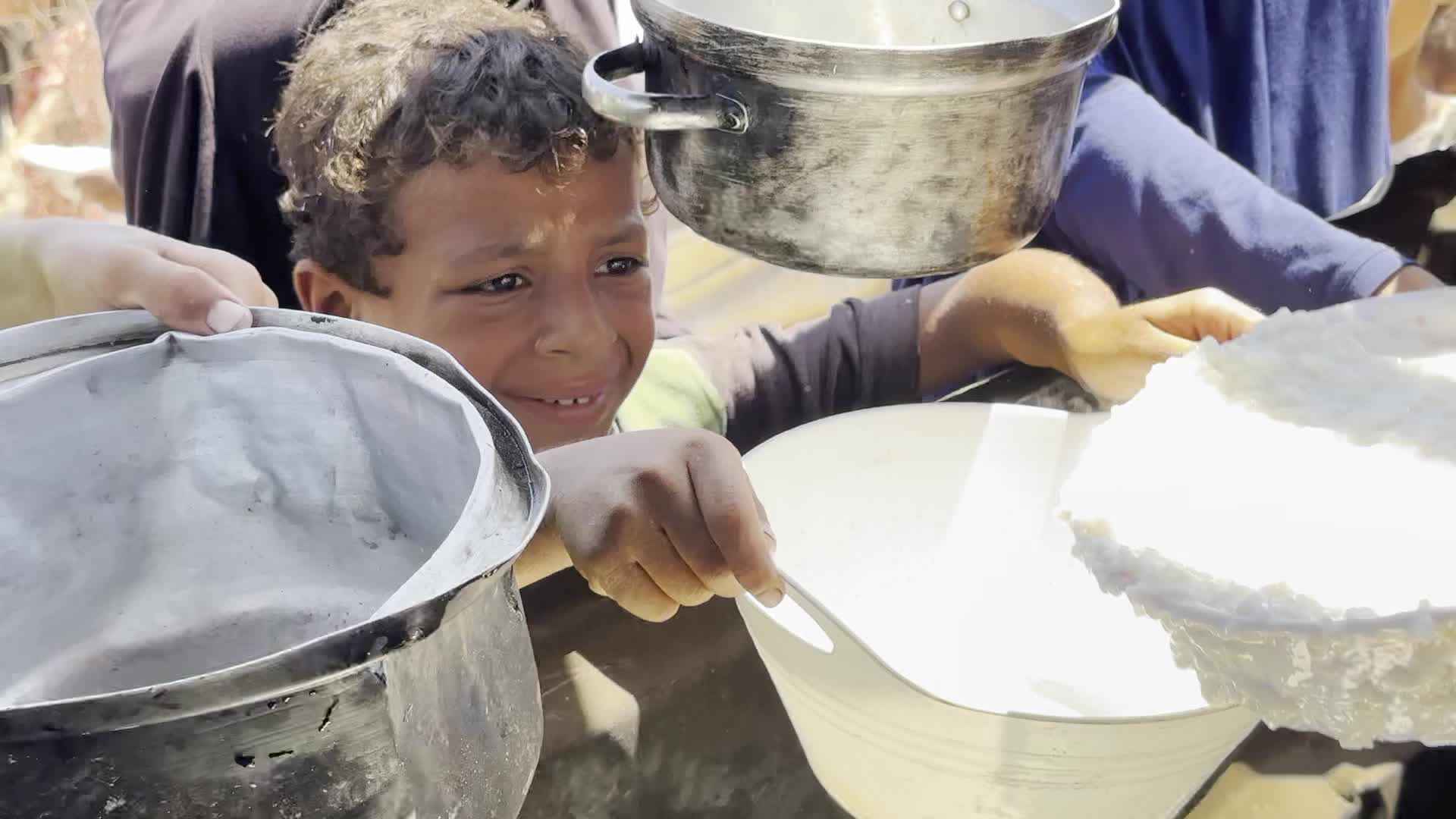 Displaced Palestinians Gather for Charity Food Distribution Amid Ongoing Israel-Hamas Conflict in Al-Zawaida, Central Gaza