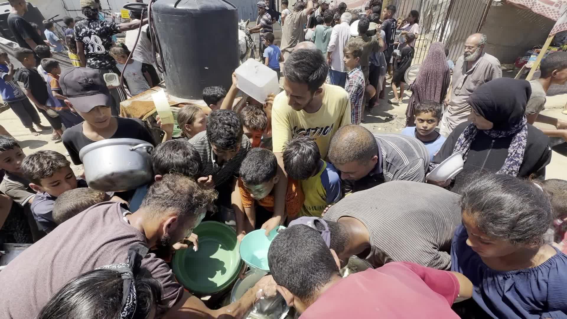 Displaced Palestinians Gather for Charity Food Distribution Amid Ongoing Israel-Hamas Conflict in Al-Zawaida, Central Gaza