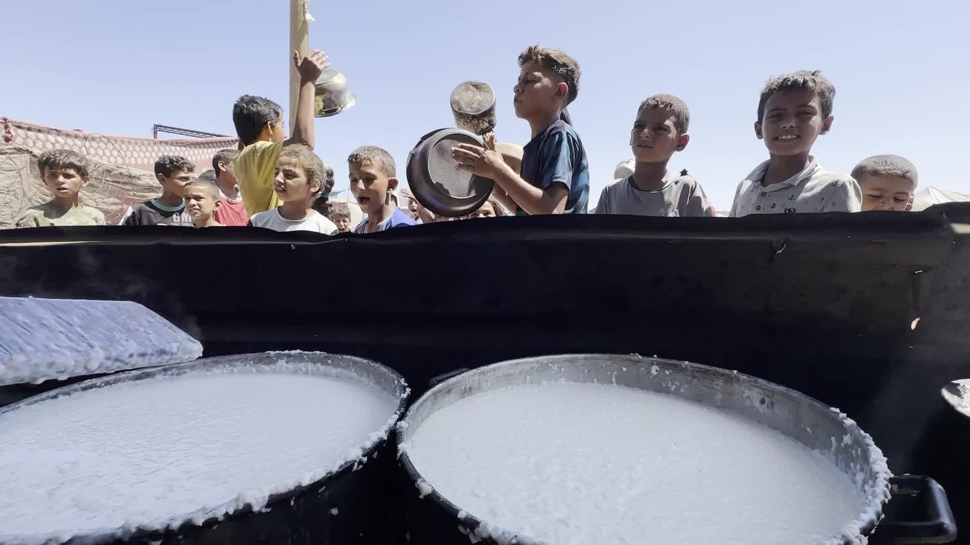 Displaced Palestinians Gather for Charity Food Distribution Amid Ongoing Israel-Hamas Conflict in Al-Zawaida, Central Gaza