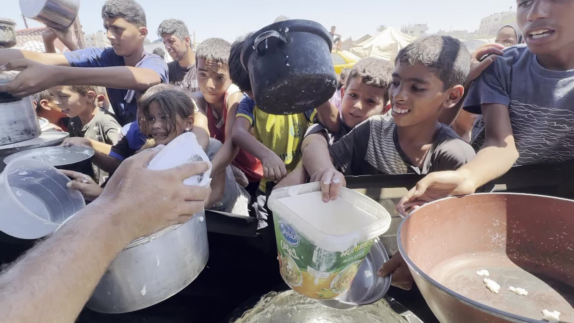 Displaced Palestinians Gather for Charity Food Distribution Amid Ongoing Israel-Hamas Conflict in Al-Zawaida, Central Gaza