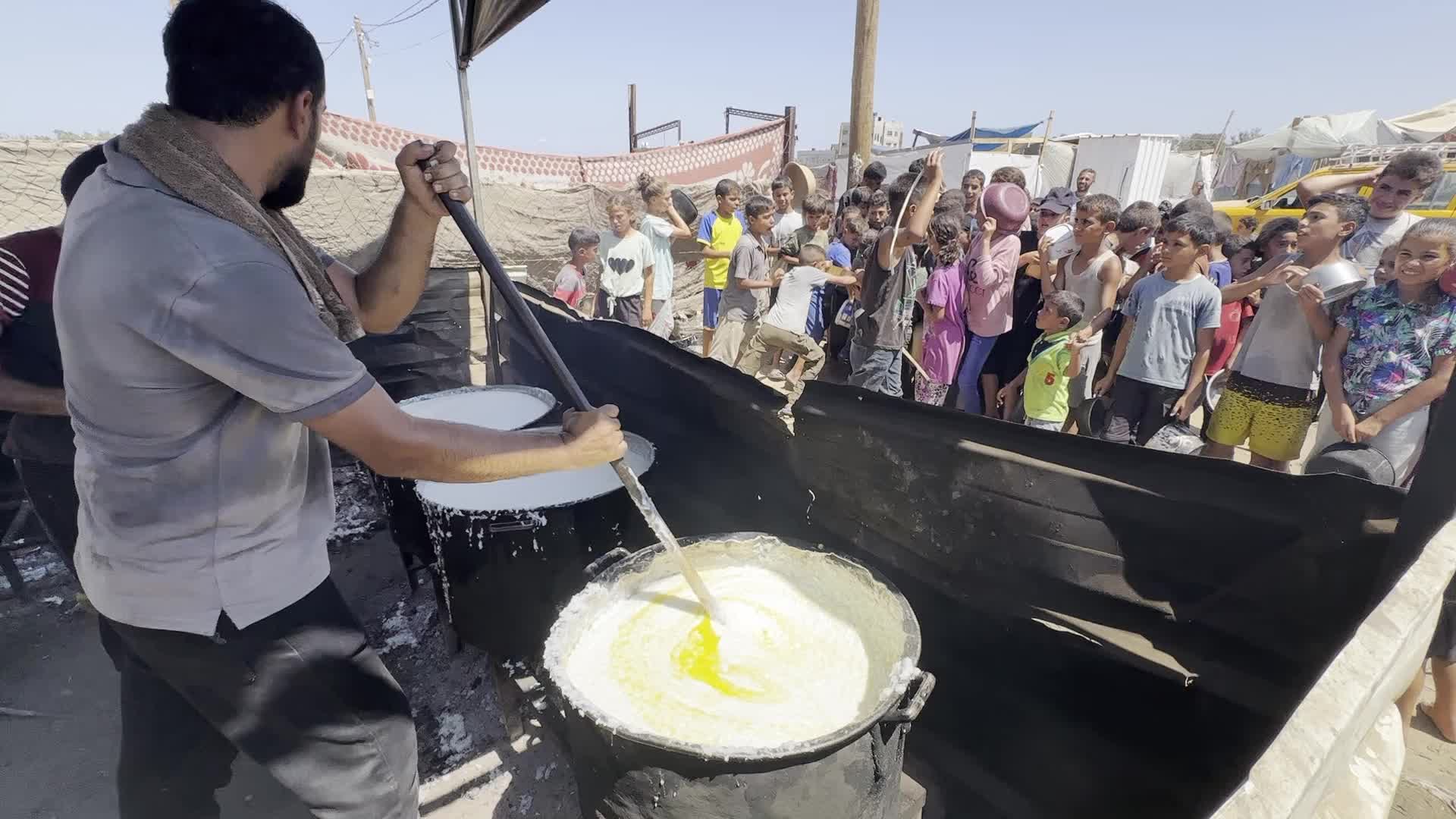 Displaced Palestinians Gather for Charity Food Distribution Amid Ongoing Israel-Hamas Conflict in Al-Zawaida, Central Gaza