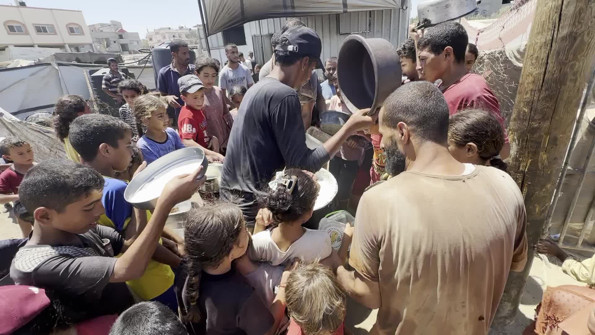 Displaced Palestinians Gather for Charity Food Distribution Amid Ongoing Israel-Hamas Conflict in Al-Zawaida, Central Gaza