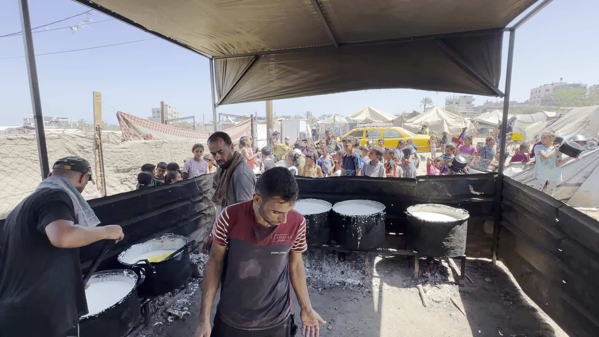 Displaced Palestinians Gather for Charity Food Distribution Amid Ongoing Israel-Hamas Conflict in Al-Zawaida, Central Gaza