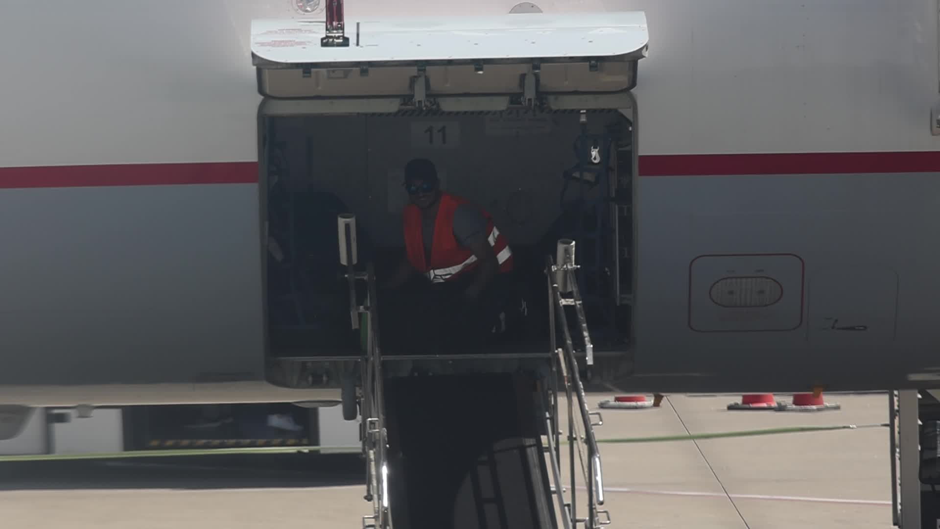 Airport workers unload luggage