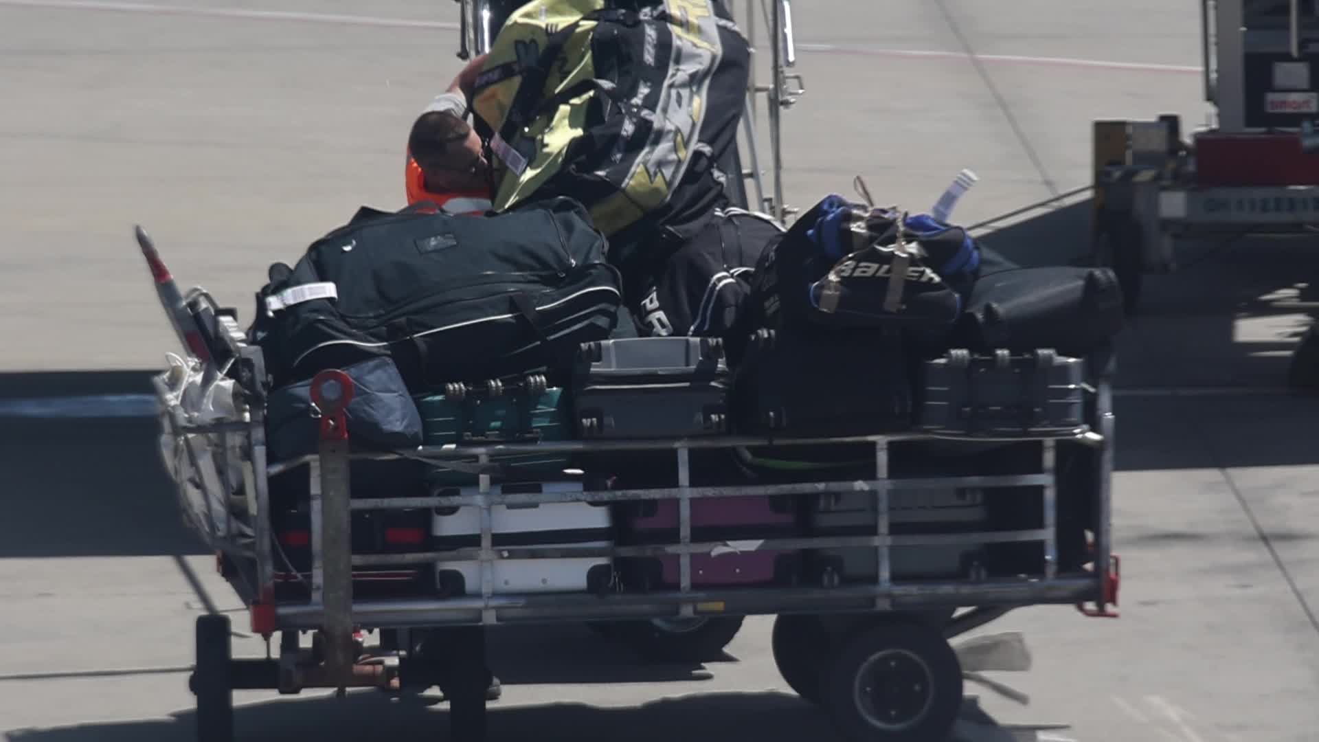 Airport workers unload luggage