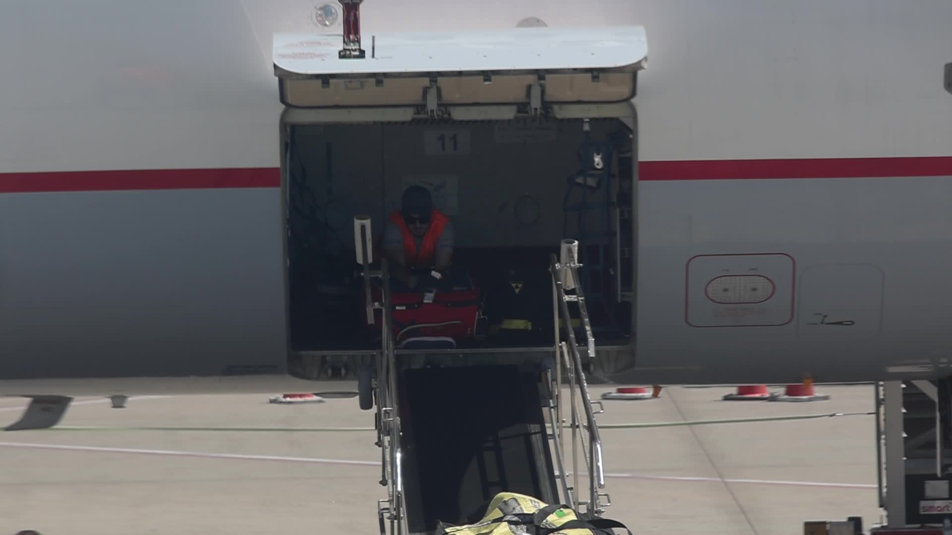 Airport workers unload luggage