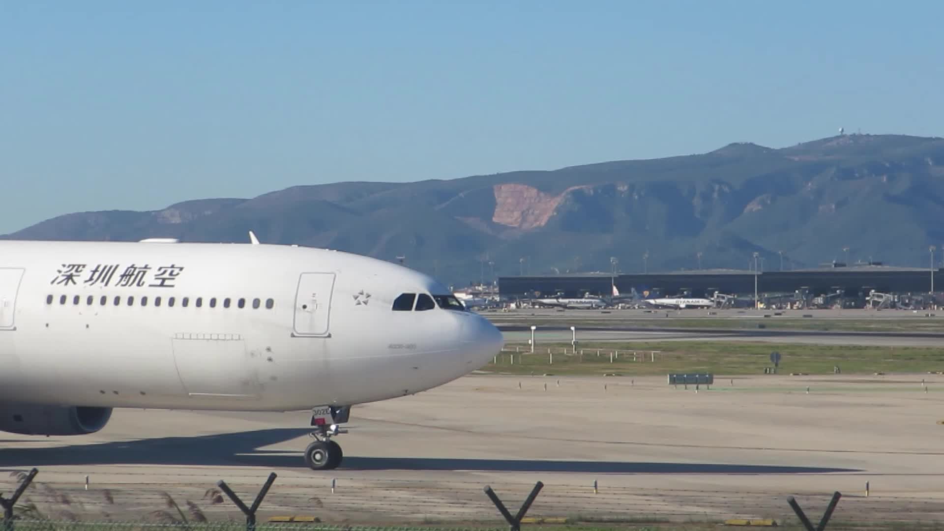 Volotea Airbus landing, while Shenzhen Airlines Airbus A330 starts takeoff at Barcelona airport