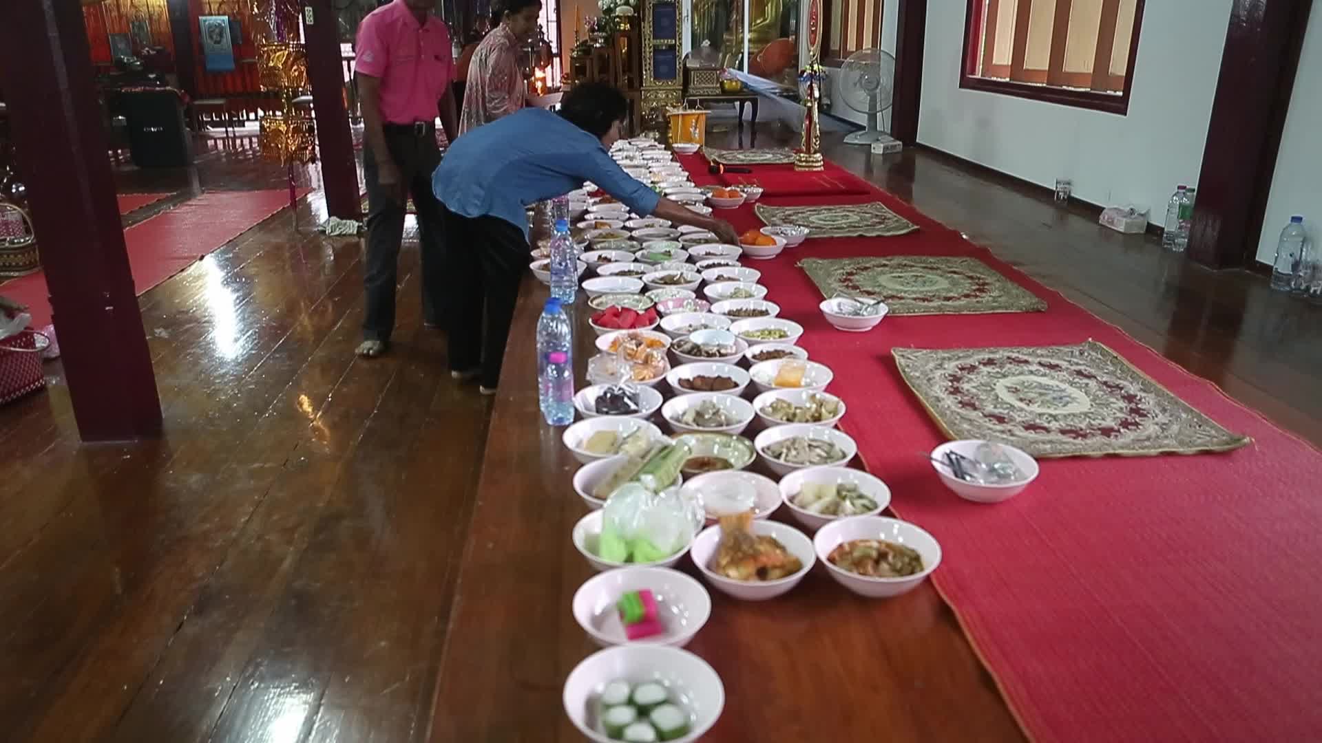 Villagers pray and join in making merit