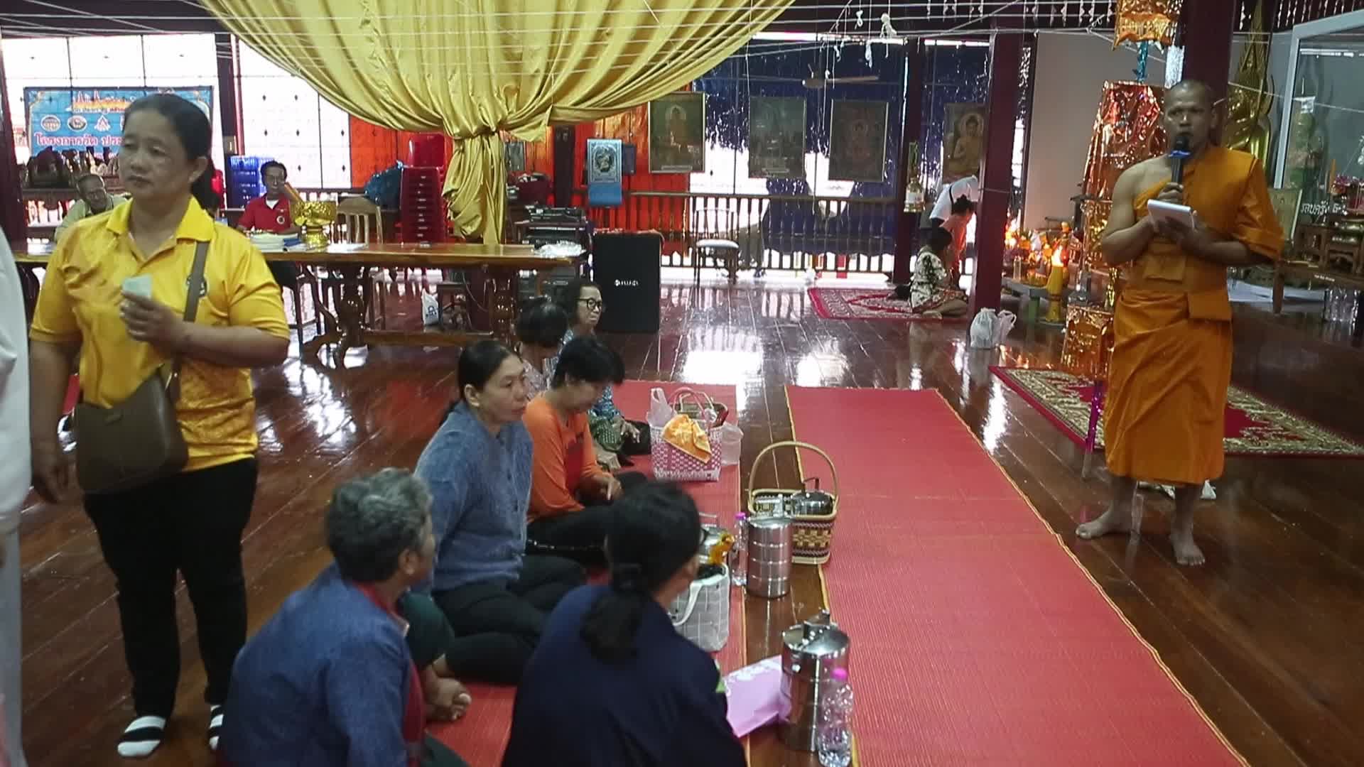 Villagers pray and join in making merit
