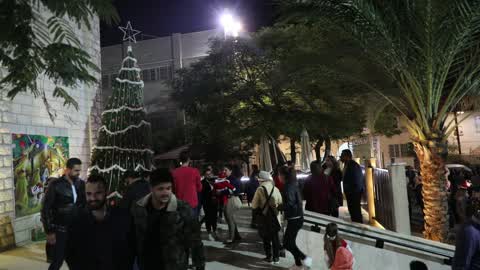 Palestinian Christians attend a Christmas tree lighting celebration
