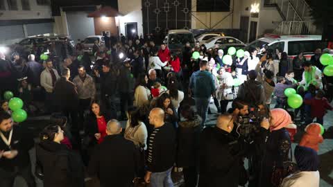 Palestinian Christians attend a Christmas tree lighting celebration