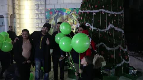 Palestinian Christians attend a Christmas tree lighting celebration