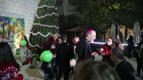 Palestinian Christians attend a Christmas tree lighting celebration