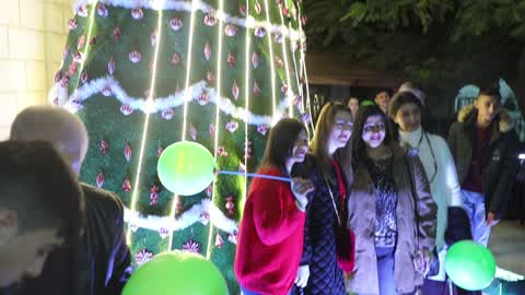 Palestinian Christians attend a Christmas tree lighting celebration