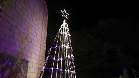 Palestinian Christians attend a Christmas tree lighting celebration