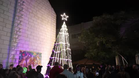 Palestinian Christians attend a Christmas tree lighting celebration