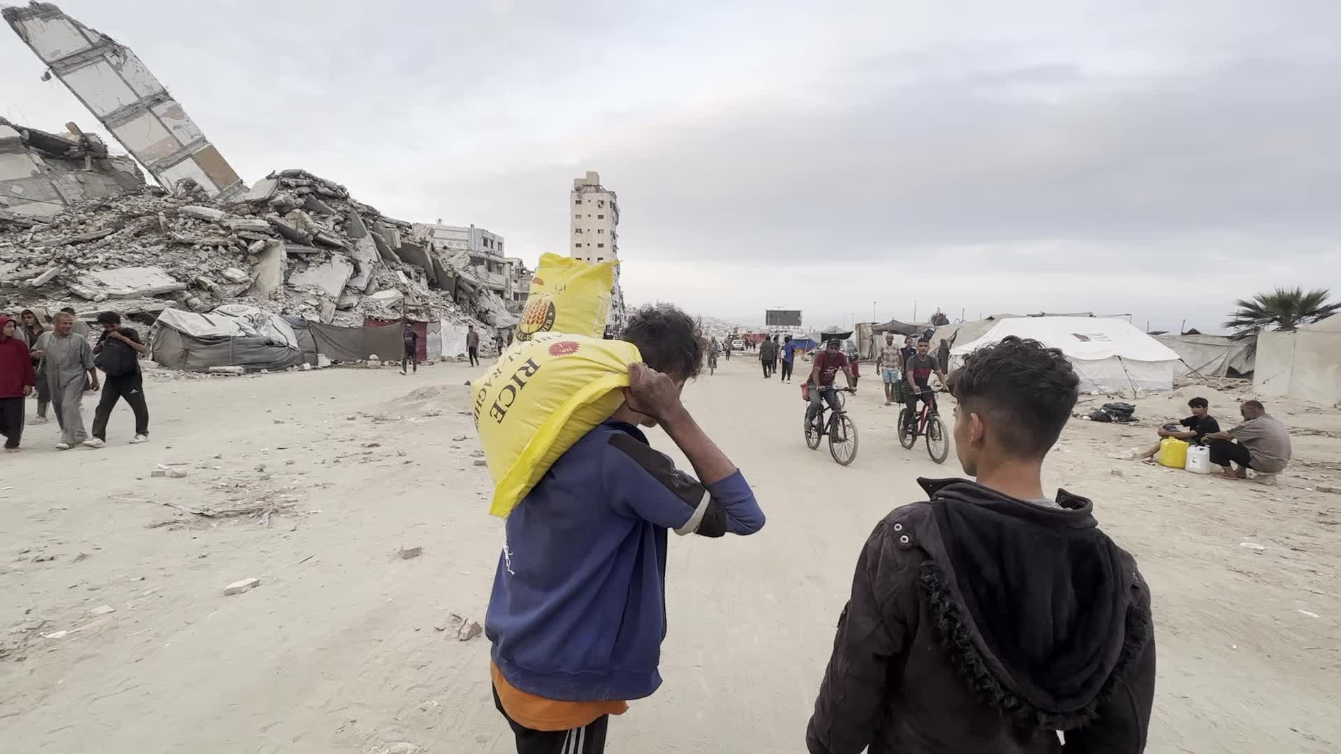 Palestinians Carry Flour in Gaza City After Aid Trucks Enter via Netzarim Crossing