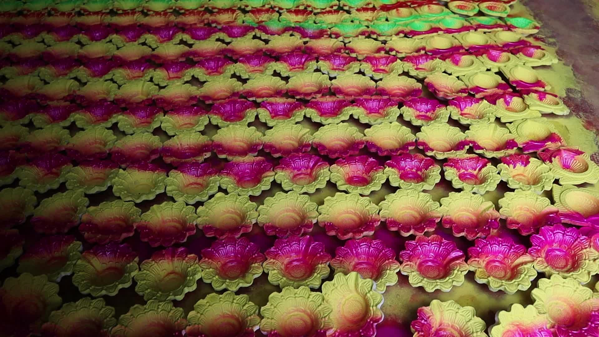 Artisans spray color on earthen lamps ahead of Diwali 
