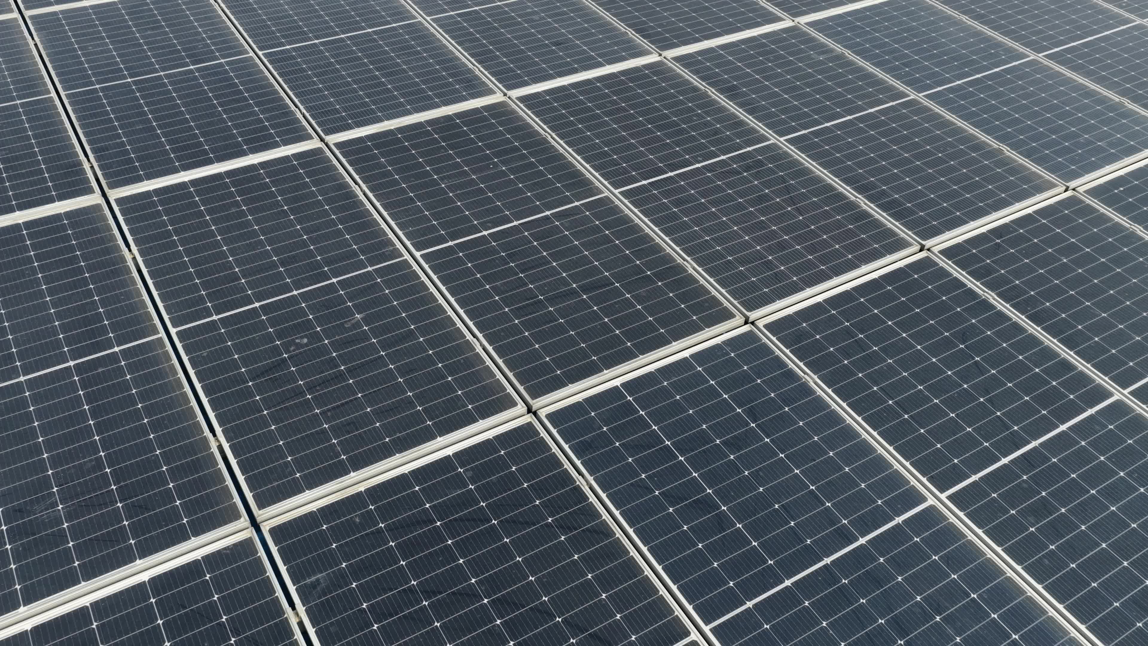 4K Aerial Drone View of Solar Panels Installed on Blue Tin Roof of Industrial Building in India