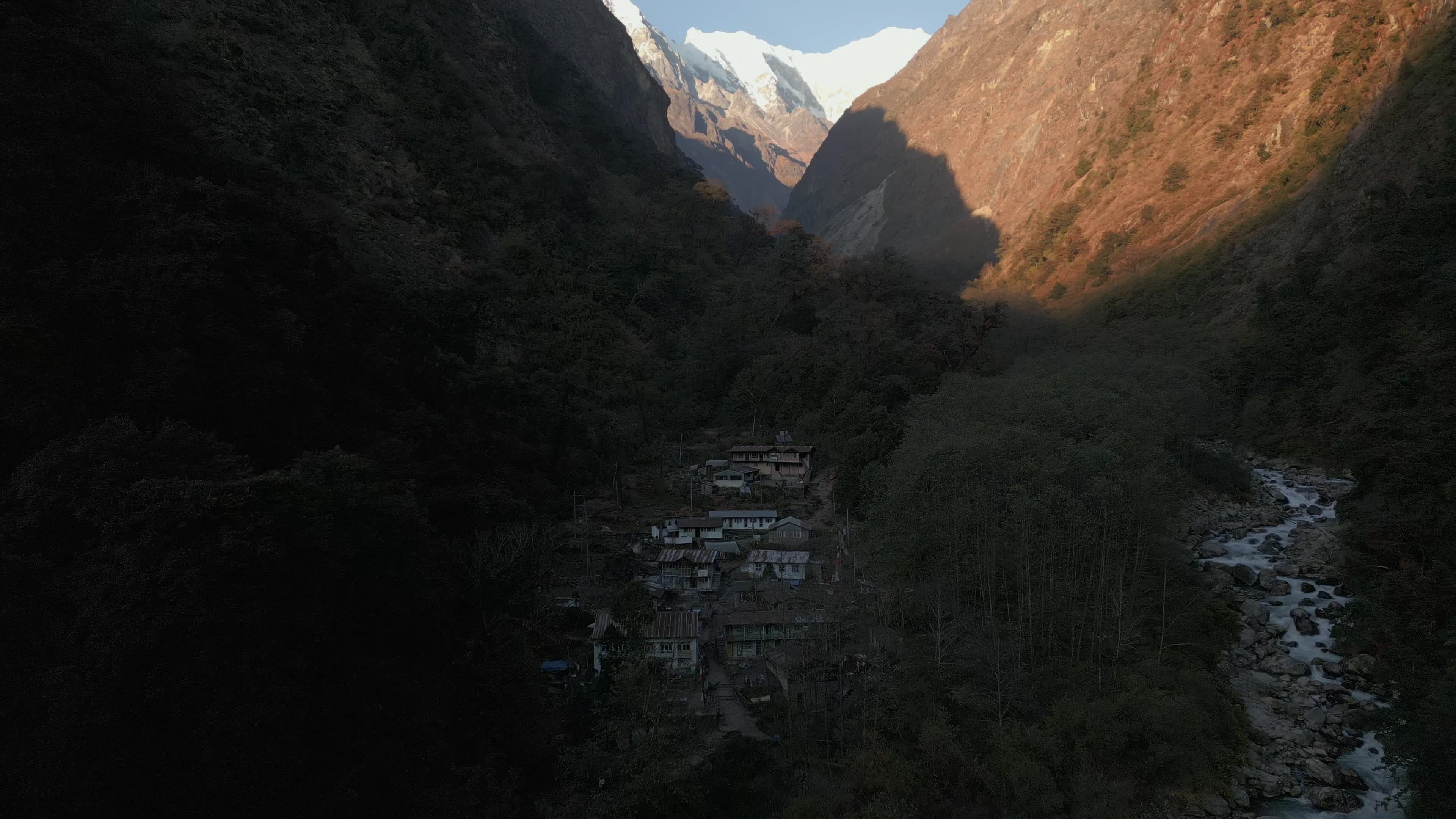 Aerial Sunset View of Langtang Mountain Village With River and Distant Snow-Capped Peaks